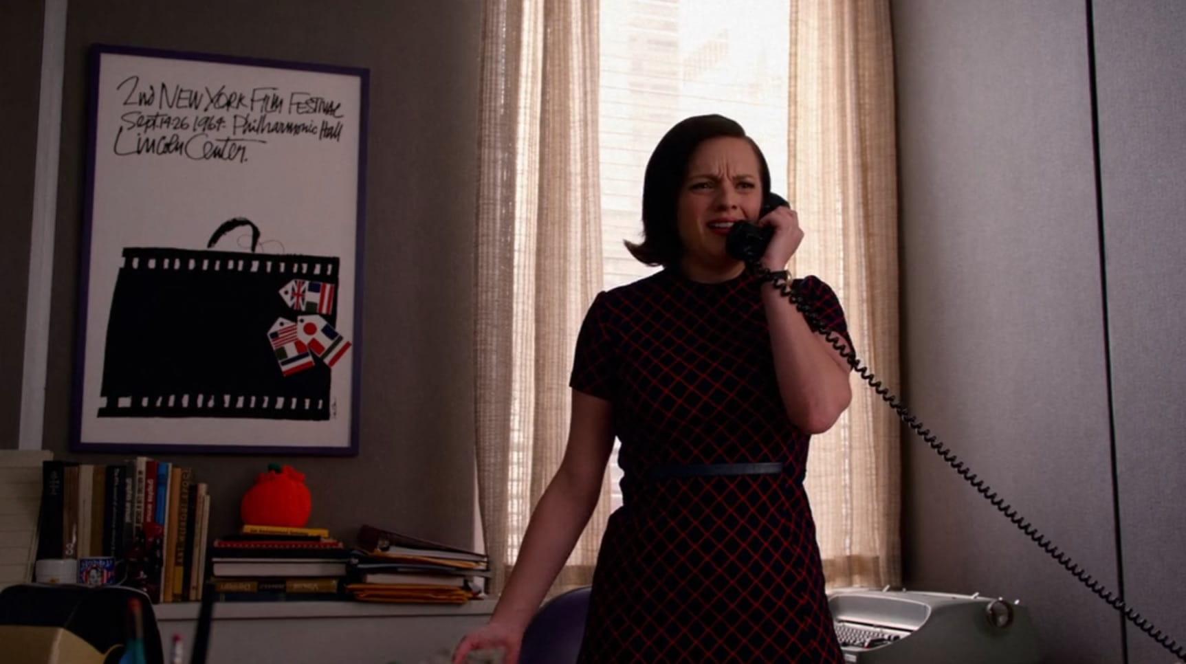 a screen grab of Peggy Olson from Mad Men in front of a poster for the 2nd New York Film Festival