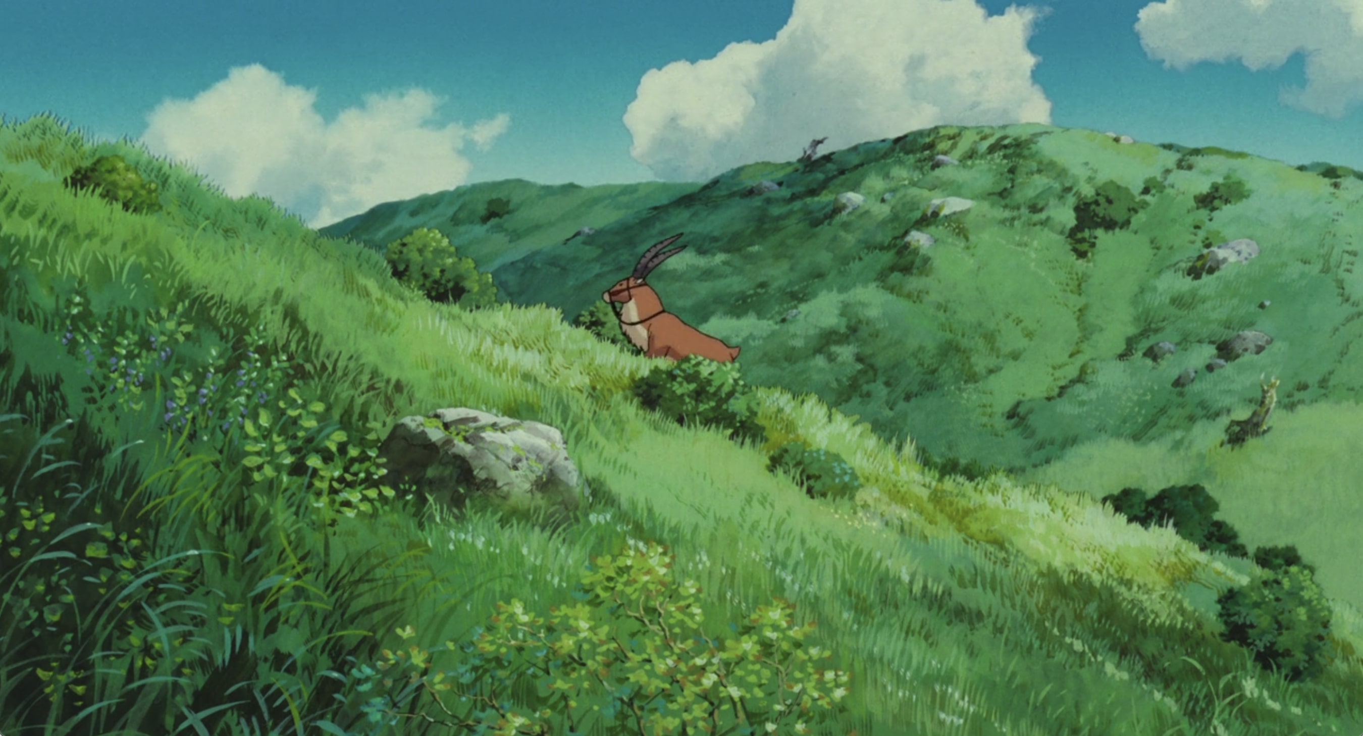 a screenshot from from the film princess mononoke where yakul is walking up a grassy hill